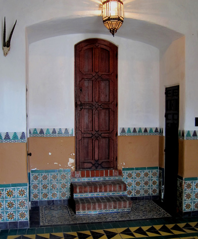 George F. Steedman and George Washington Smith designed garage at Casa del Herrero, Montecito California showcases authentic antique Spanish tiles from Spain, and Spanish Revival wood arch top door
