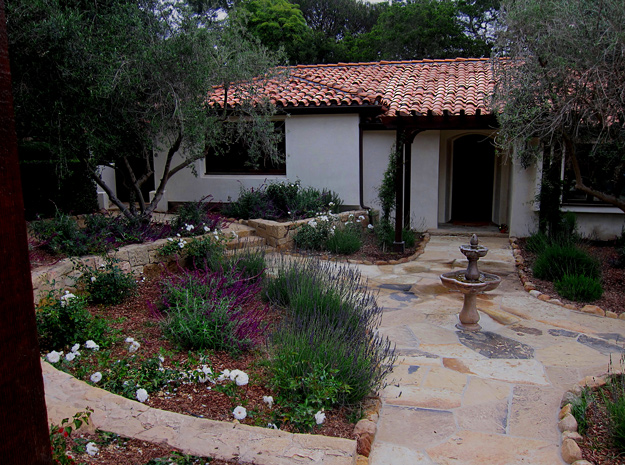 Mediterranean, drought tolerant landscape and flagstone walkway and cast concrete fountain in Montecito, California